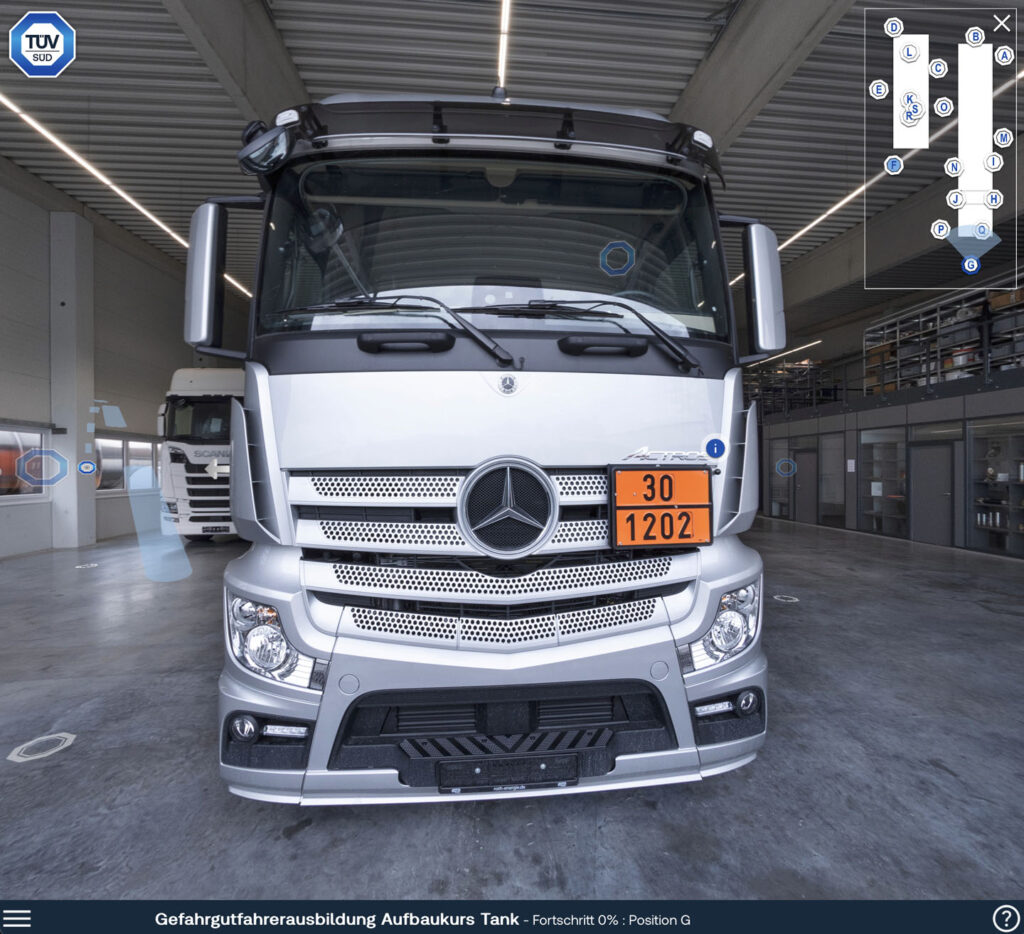 The initial view of the training shows the front grill of the articulated truck. There is an info point for the orange information panel and options to travel into the cabin or around the vehicle