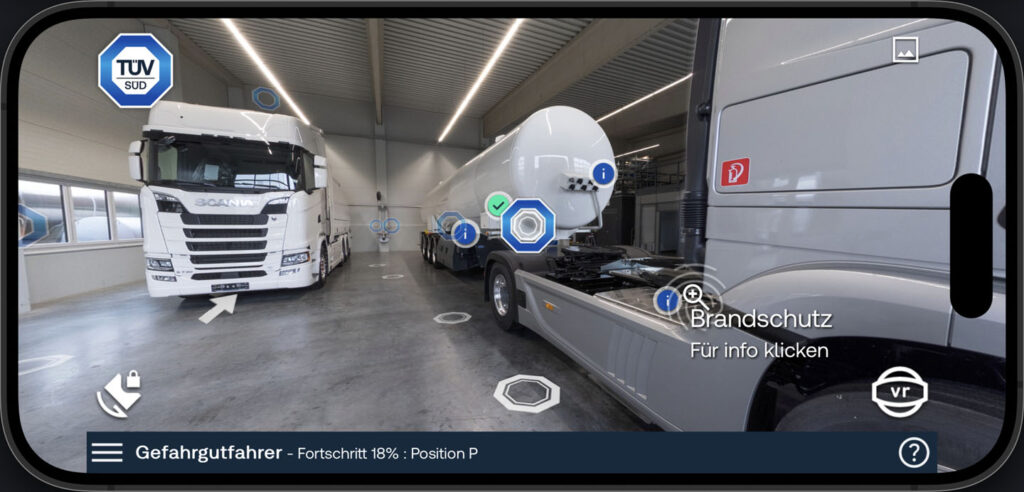 Capture from the mobile phone version of immersive training for dangerous goods vehicles, showing an articulated and fixed-wheel truck with fire protection information and navigation points.